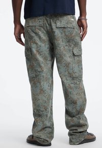 Cargo-Hosen in einem digitalen Tarnmuster, mit einem gedämpften grünen Grundton und braunen Akzenten, mehreren Taschen und einem lässigen Schnitt.