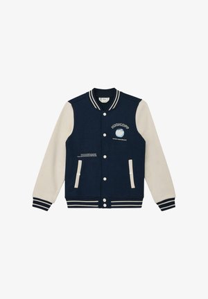 Veste universitaire bleu marine et blanche avec col et poignets rayés, boutons pression, deux poches avant, et texte "KICKOFF Chase Your Dreams" accompagné d'un motif globe.