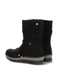 Botines de ante negro con diseño arrugado, puntera redonda y detalles decorativos en dorado; suela gruesa de goma gris con textura en el dibujo.