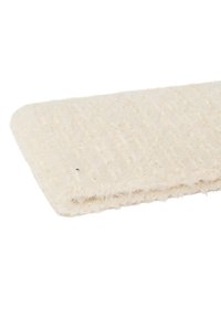 Miękki, kremowy dywan o teksturowanej, puszystej powierzchni. Charakteryzuje się subtelnym połyskiem i gładką, zaokrągloną krawędzią. Ma kształt zbliżony do prostokąta.