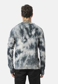 Leichter Strickpullover in Grau und Weiß mit einem Batikmuster. Mit Kabelstrick-Ärmeln sowie einem gerippten Halsausschnitt und Saum.