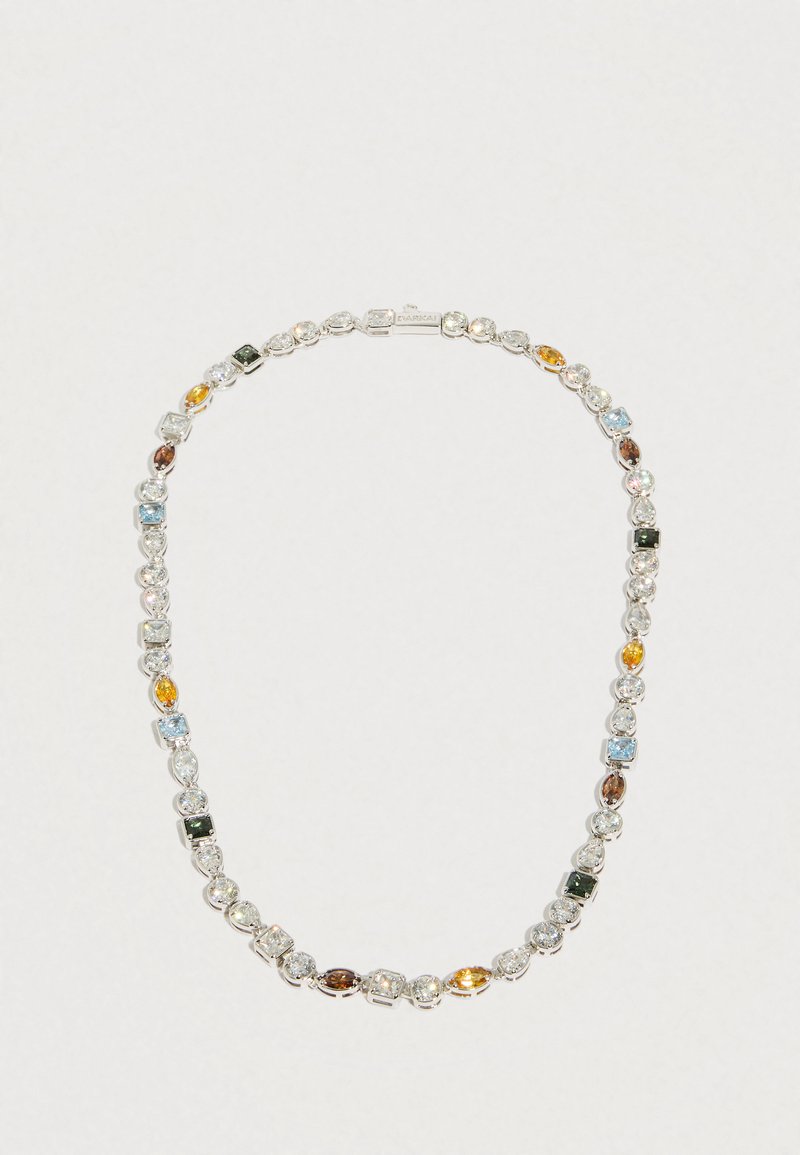 Srebrny naszyjnik z na przemian ułożonymi okrągłymi, kwadratowymi i marquise kamieniami szlachetnymi w odcieniach: przezroczystym, niebieskim, żółtym, zielonym i brązowym na białym tle.