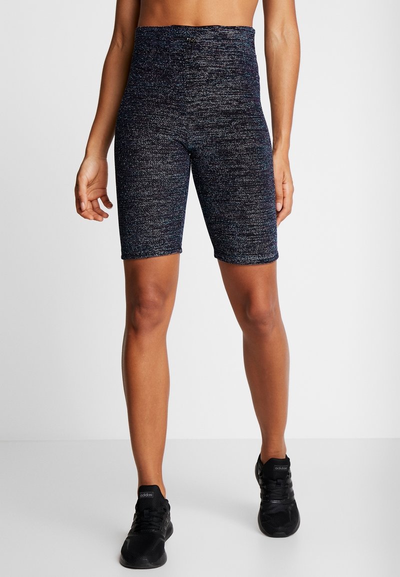 Cuissards de cyclisme taille haute en tissu bleu foncé à motifs tachetés multicolores. Présentent une coupe ajustée et une texture lisse et extensible.