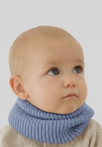 Chauffe-nuque tricoté bleu clair avec une texture côtelée, porté par un bébé, associé à un pull beige. Tissu lisse, aspect doux.