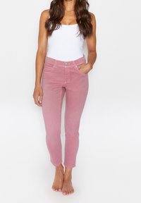Růžové slim-fit džíny s páskem uprostřed, pěti kapsami a zapínáním na knoflík. Materiál má hladkou strukturu a mírně vybledlý vzhled.