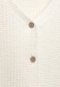 Biała dziergana kardigan z dekoltem w serek, z dwoma drewnianymi guzikami i textured, plecionym wzorem.