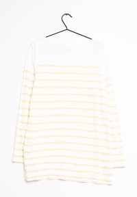 Chemise blanche à manches longues avec des rayures jaunes horizontales, fabriquée en tissu doux, avec un col rond et une coupe décontractée.