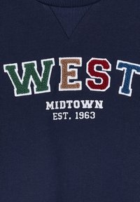 Marineblaues Sweatshirt mit mehrfarbig gesticktem Text: "WEST" in Grün, Braun, Rot und Blau sowie "MIDTOWN EST. 1963" in Weiß.