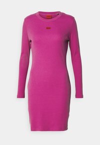 Obtažené dlouhé šaty v živě růžové žebrované látce, které mají kulatý výstřih a malou červenou značku s logem na hrudi.