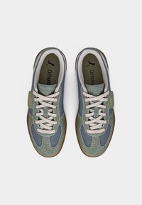 Grønne og blå joggesko med en kombinasjon av semsket skinn og mesh-materialer. Gummisåle, grå lisser og "Ortholite"-merke inne.