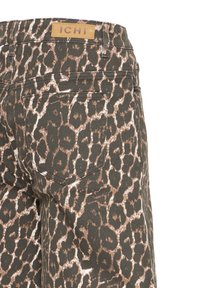 Pantalon en denim à imprimé léopard avec poche arrière et étiquette de marque en cuir "ICHI" sur la ceinture, vu de profil.