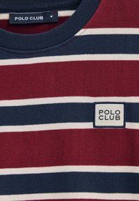Röd och marinrandig t-shirt med rundad hals, med vita ränder, och en logoemblem "POLO CLUB" på bröstet. Tillverkad av bomull.