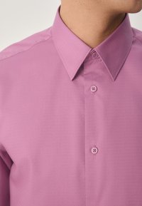 Hellviolettes, strukturiertes Hemd mit spitzem Kragen, mit Knöpfen in passendem Farbton und tailliertem Schnitt.