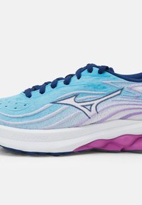 Scarpa da ginnastica azzurro chiaro con tessuto testurizzato, dettagli viola e rosa, forma arrotondata e lacci blu. Marchio sul lato.