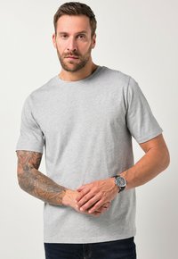 Grå bomuld t-shirt med korte ærmer, rund halsudskæring og et grafik på venstre front, der står "GREAT LAKE ONTARIO," kombineret med mørke jeans.