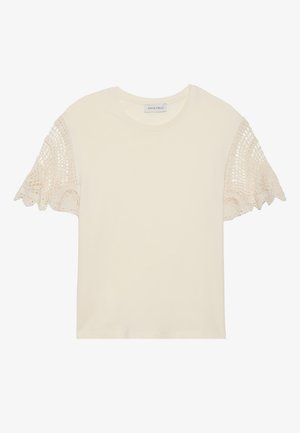 T-shirt crème à manches courtes avec des accents en dentelle en crochet beige. Tissu en coton doux, encolure ronde, coupe décontractée.