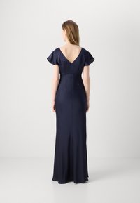 Rochie de seară din satin bleu marin, cu mâneci scurte și voluminoase, design cu decolteu în V pe spate și o siluetă ajustată care se extinde până la podea, având o fanta subtilă.