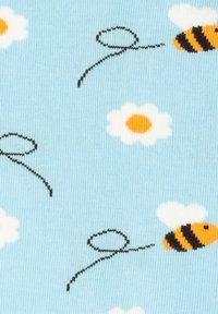 Jasnoniebieska tkanina z małymi ilustracjami żółtych i czarnych pszczół, białych stokrotek z pomarańczowymi środkami oraz czarnych, krętych linii.