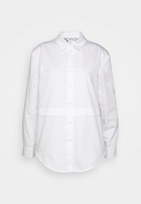 Camicia bianca con bottoni realizzata in cotone morbido. Presenta un colletto classico, maniche lunghe e un orlo arrotondato con un sottile dettaglio a pannello.