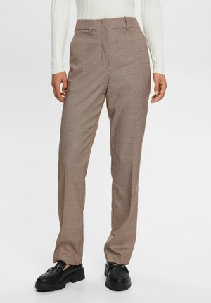Pantalon à carreaux marron avec une coupe ajustée, présentant une texture lisse, des poches latérales et une coupe droite. Des chaussures noires complètent le look.