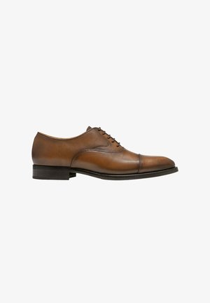 Chaussure habillée Oxford marron en cuir pour homme avec bout droit, laçage fermé et petit talon empilé noir, présentée de profil sur fond blanc.