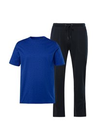 Camiseta de manga corta azul con un pequeño patrón de puntos negros y pantalones de chándal negros con cordón, que cuentan con bolsillos laterales y un corte relajado.