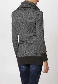 Szary sweter z marszczeniami, z kapturem, długimi rękawami i ciemniejszym dolnym paskiem. Posiada akcent w postaci metki blisko brzegu.