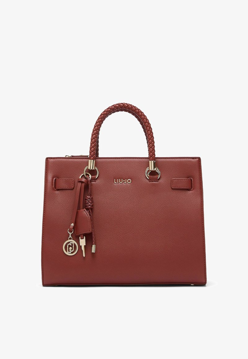 Sac à main rectangulaire en cuir marron avec poignées tressées, ferrures dorées, pampilles décoratives et un petit charm marqué.