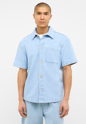 Helles blaues Kurzarmhemd aus Denim mit einem Kragen, Knöpfen in der Vorderseite und einer Brusttasche. Strukturierter Stoff mit dezenten Streifen.