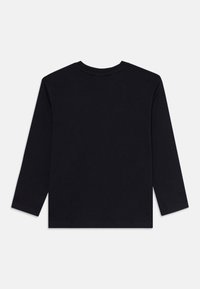 Musta pitkähihaisia crewneck-paita asetettuna tasaiselle pinnalle, näkyy takaa, jossa on sileä ja yksinkertainen rakenne valkoista taustaa vasten.