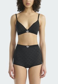 Zwart lingeriesetje met een driehoekige bralette en hooggetailleerde slip. De stof heeft een subtiel gestructureerd patroon met een witte logo-accent.