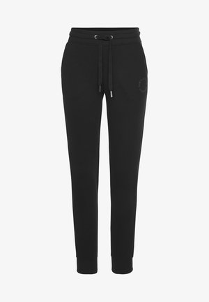 Schwarze Jogginghosen mit einem Kordelzugbund, schmal zulaufenden Beinen und elastischen Bündchen. Auf der oberen linken Seite befindet sich ein dezentes Logo. Material aus Baumwollmischung.