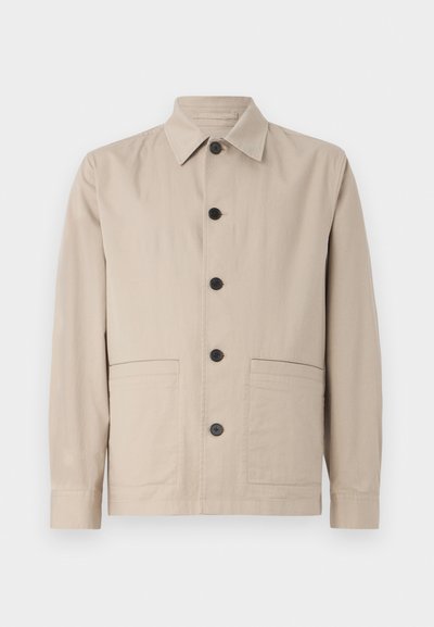 Jachetă bej cu guler, închidere cu buton frontal și două buzunare aplicate. Confecționată dintr-un material ușor, cu o textură netedă.