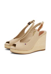 Beige kile-sandaler med en peep-toe design. Laget av lerret, med en vevd jute-plattform og lærdetaljer. Justerbar stropp med spenne.
