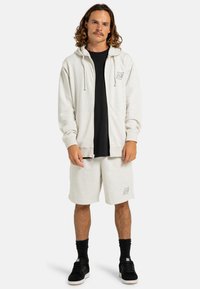 Gray zip-up hoodie with drawstrings, black t-shirt underneath, coordinated gray shorts, black socks, and black shoes with white soles.