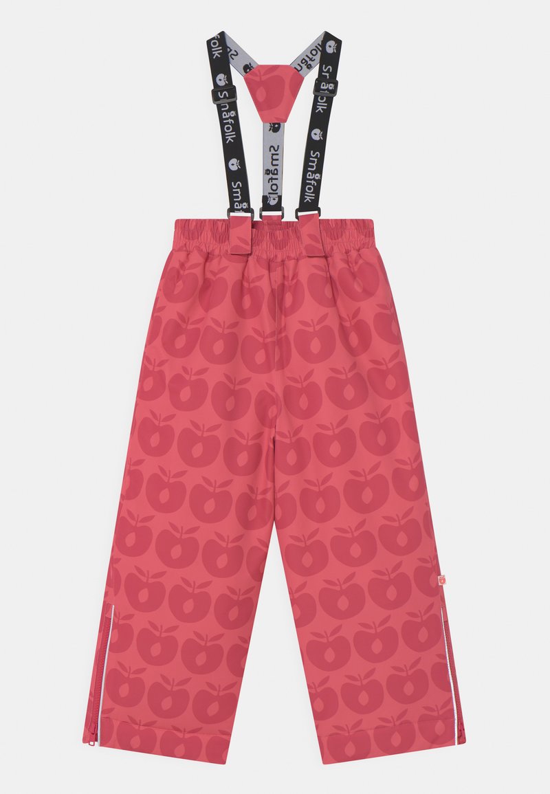 Calças impermeáveis rosas com padrão de maçã, suspensórios ajustáveis pretos, cintura elástica e fechos laterais para fácil vestibilidade.