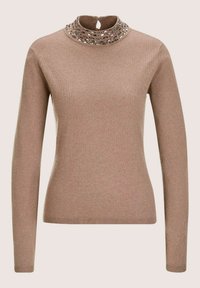 Langsleeve fitted beige trui met een hoge nek, voorzien van zilveren ovale versieringen en een kleine opening met sleuteltje aan de achterkant.