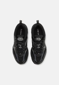 Černé sportovní boty s síťovinou a syntetickými překryvy, s kulatou špičkou, šněrováním vpředu a poutkem na patě pro snadné obouvání.