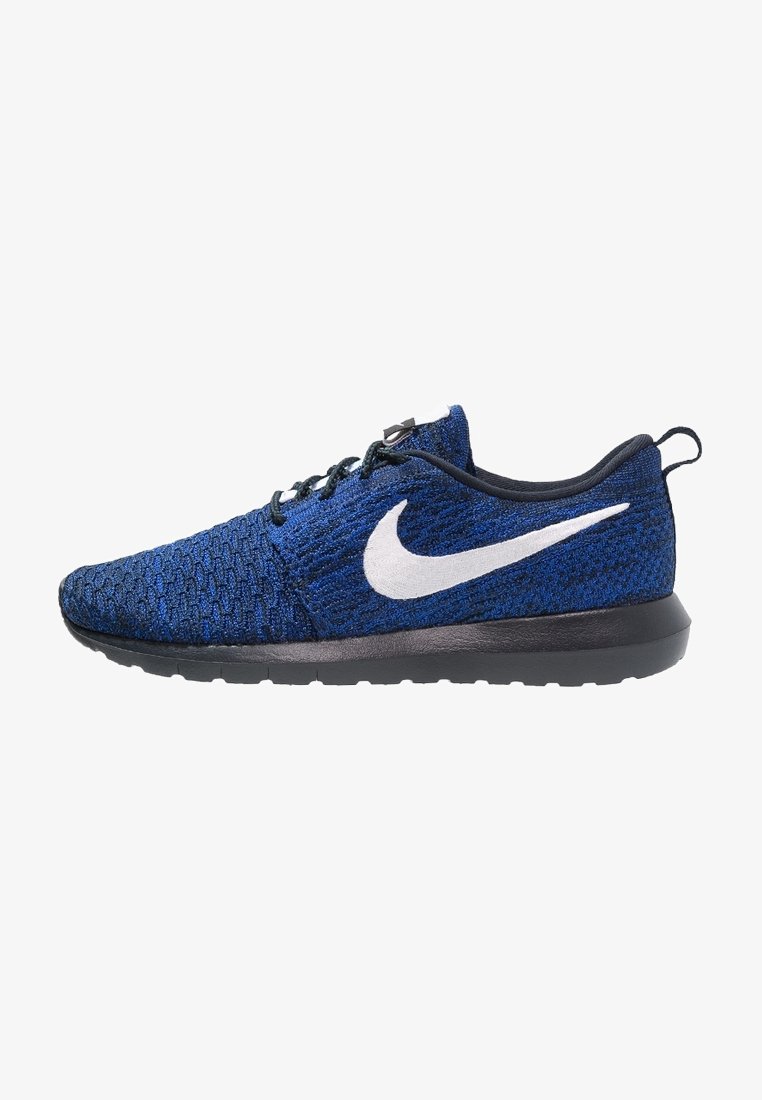 Niebieski but do biegania Nike z czarną podeszwą, białym logo Swoosh, czarnymi sznurowadłami i fakturowaną dzianinową cholewką, widoczny z boku.