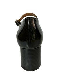 Zapato de tacón alto de charol negro con punta redonda y tacón grueso. La correa es de cuero marrón, unida en la parte trasera.