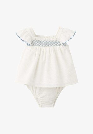 Combinaison bébé blanche texturée avec manches papillonnantes, détail smocké bleu sur la poitrine et bloomers attachés.