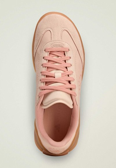 Pink athletic shoe with a suede upper, round toe, and rubber sole. Features tonal laces and a cushioned tongue. Simple, clean design.