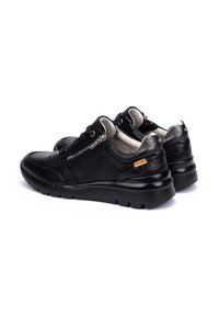 Schwarze Lederschuhe mit texturiertem Finish, ausgestattet mit einem seitlichen Reißverschluss, gepolstertem Kragen und einer dicken, flexiblen Sohle für Komfort.
