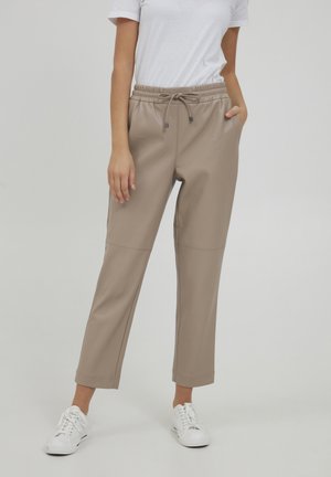 Beige faux lær joggere med elastisk midje, snøring og sidelommer. Tapered bein design med sømdetaljer.