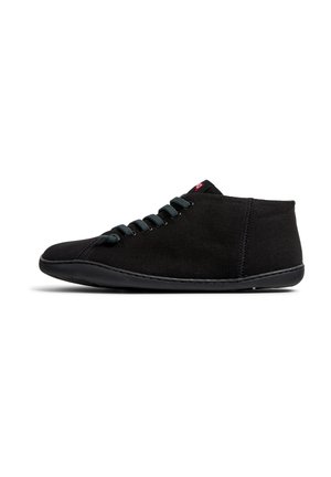 Zapatilla alta negra con parte superior de tela, puntera redonda y cordones verdes. Cuenta con una suela texturizada y costuras en contraste a lo largo de los lados.