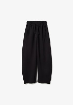 Pantaloni della tuta neri a gamba larga con vita elastica e coulisse. Presentano cuciture laterali per una vestibilità comoda. Tessuto dalla texture morbida.