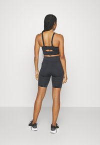 Under Armour SMARTFORM EVO MID - Sportovní podprsenky se střední oporou - black/white