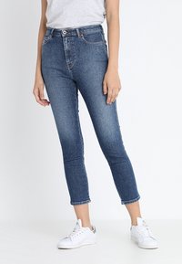 Smala jeans i medelblå denim, hög midja, med en lätt urtvättning. Har knapp- och dragkedjestängning, fickdetaljer och ankellängd.