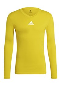 Gul långärmad träningsskjorta med V-ringning och vitt Adidas-logotyp centrerad på bröstet.