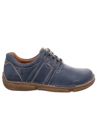 Zapatos de cuero azul marino con costuras en contraste y suela de goma marrón. Presentan un diseño de perfil bajo y cierre con cordones. Lados texturizados.